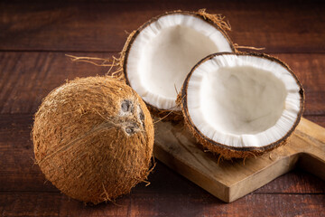 Obraz na płótnie Canvas Whole coconut and pieces of coconut on the table.