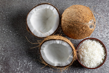 Obraz na płótnie Canvas Whole coconut, pieces of coconut and shredded coconut on the table.