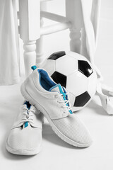 Sportive male sneakers and football accessories on white background