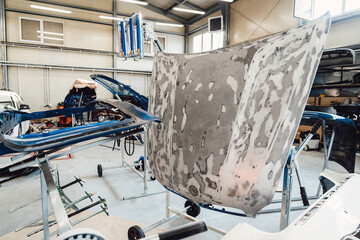 Painting and drying of car body parts after applying putty and paint on hood in the body repair...