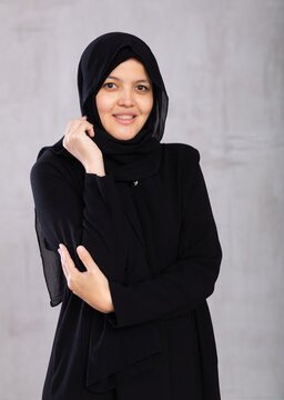 Closeup portrait of young smiling woman in hijab posing in studio