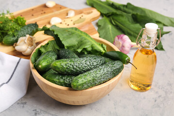 Bowl with fresh cucumbers  for preservation on grunge background