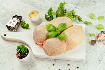 Chicken leg meat.Raw fresh chicken leg meat with skin on a light background with fresh herbs.Food for retail.Procurement for designers.Ogranic food,healthy eating.Food concept.Top view.