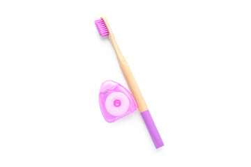 Dental floss and bamboo toothbrush isolated on white background