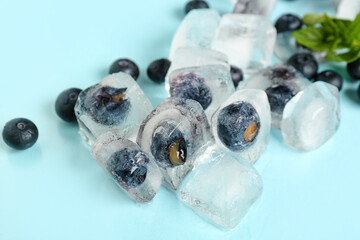 Fresh blueberry frozen in ice on blue background