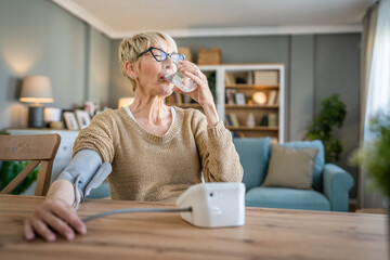 Senior caucasian woman check blood pressure measure device on hand