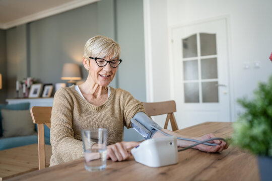 Senior caucasian woman check blood pressure measure device on hand