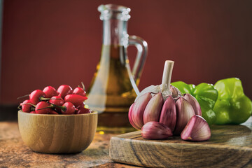 Garlic in Close Up with red pepper and olive oil to the red background.