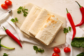 Board with fresh lavash on light background