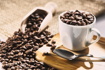  Cup full of coffee beans with metal spoon and wooden spoon