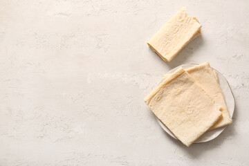 Plate with fresh lavash on light background