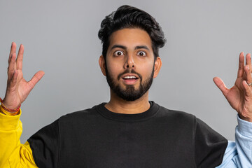 Excited amazed indian man touching head and showing explosion, looking worried and shocked,...