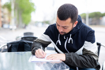 Portrait of man who is writes documents in time lunch in a cafe