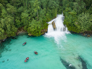 An amazing waterfall tumbles out of rainforest and into the ocean on the coast of West Papua, Indonesia. This beautiful area, near Momon, harbors extraordinary terrestrial and marine biodiversity.
