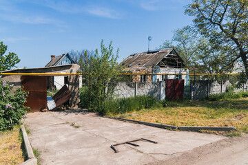 Fototapeta na wymiar Countryside. Yard in front of the house destroyed by shelling. War in Ukraine. Russian invasion of Ukraine. Terror of the civilian population. War crimes