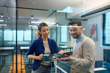 Obraz premium Young colleagues cooperating while working on touchpad in office.