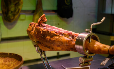 Leg of pork serrano Iberian cured jamon on stand in Spanish butcher's shop