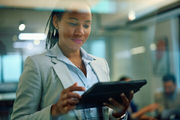 Black female insurance agent working on touchpad in office.