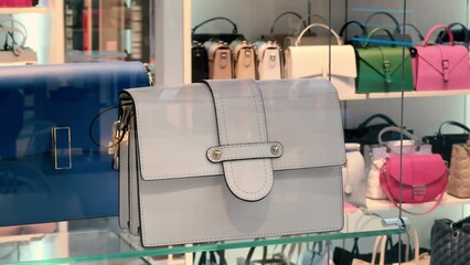 Women's leather handbags on a glass shelf of an accessories store