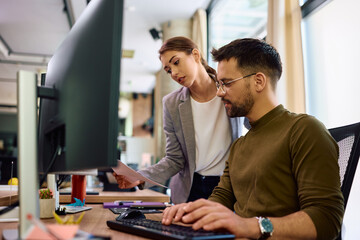 Young business colleagues cooperating while working in office.