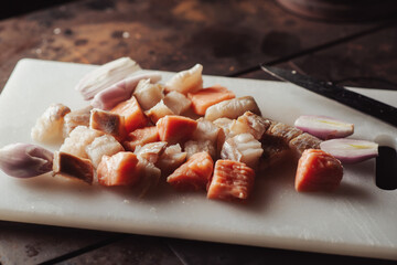 Pieces of raw fish cut on a cutting board. Red and white fish. Cooking.