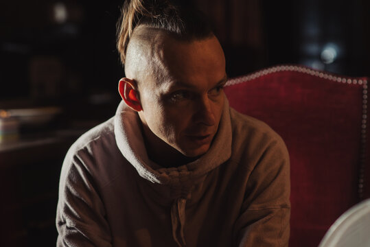 Middle-aged man in a dark room. Ordinary man of thin build. - Powered by Adobe