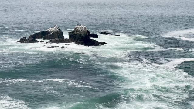 Ocean surge off Crescent Bay in Laguna Beach anchored by a small island with shorebirds