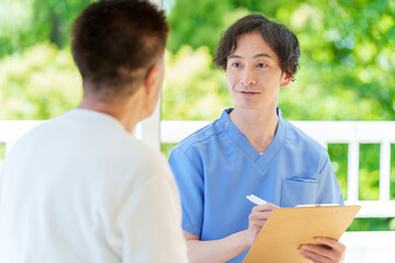 医師の診察を受けるシニア男性