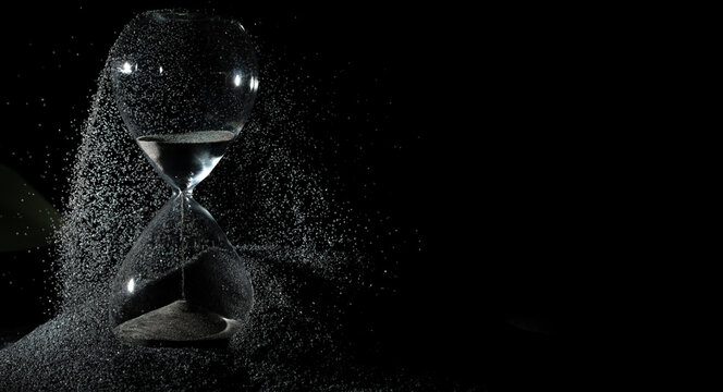 Hourglass add more sand of time on black sand over black background. Black hourglass show more time Deadline extended time management hope concept hour glass, life clock passing by