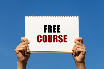 Free course text on notebook paper held by 2 hands with isolated blue sky background. This message...