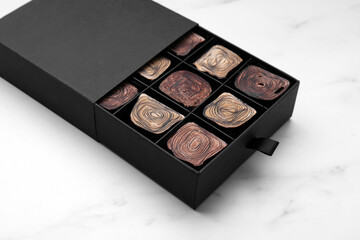 Box of tasty chocolate candies on white table