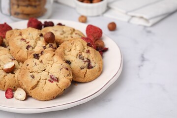 Cookies with freeze dried fruits and nuts on white marble table, closeup. Space for text