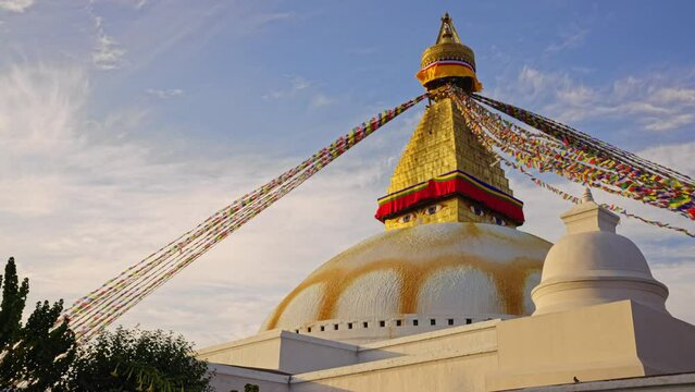 Slow tracking movement of the Boudhanath Stupa and prayer flags at sunset, Kathmandu, Nepal