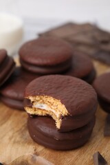 Tasty choco pies on wooden board, closeup