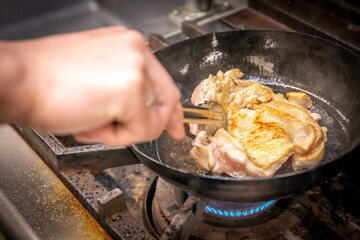 chef cooks chicken　厨房で鶏肉を炒めている