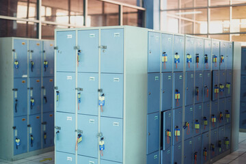 A row of blue metal library lockers with keys in the doors