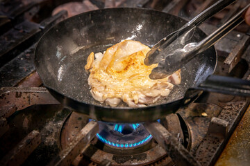 chef cooks chicken　厨房で鶏肉を炒めている