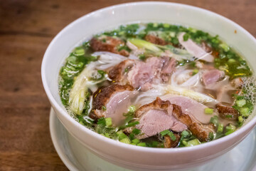 Vietnamese pho with duck with crispy skin, green onions and herbs