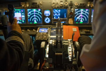 Close-up of the hands of the pilots on the controls of the aircraft. 