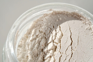 An open jar of face scrub-powder showing off its texture. - obrazy, fototapety, plakaty