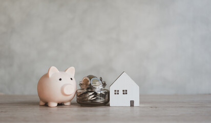 Piggy bank with a full of coins and mini home. Property investment and saving for buy house...