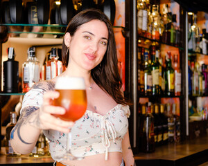 Happy waitress offers a cold beer in a nightclub