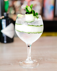 A glass of mojito cocktail with blurred background.