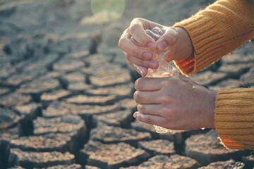 The last drop of water in the hand on the barren ground