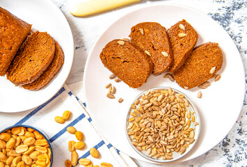 Homemade halva with peanuts and sunflowers on a white plate