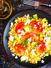 Fresh bulgur salad with tomatoes, avocado and feta cheese. Vegetarian salad with bulgur