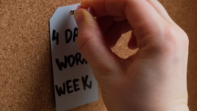 Hand pin note 4 day work week text on paper note pinned to desk four day working week concept. Modern approach doing business short workweek. Effectiveness of employees. Productivity and efficiency