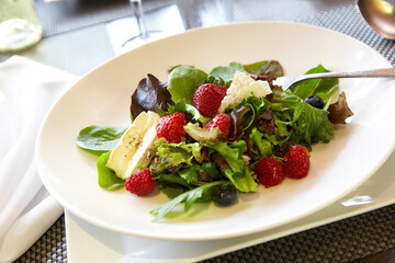 Fresh, organic salad greens with strawberries, blueberries, cheese and other healthy items.