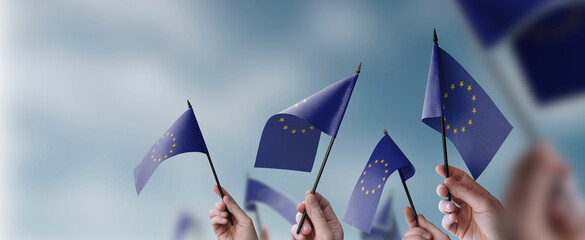A group of people holding small flags of the European Union in their hands - 603556559