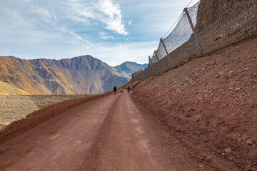 estrada de terra e grade de metal para contenção de rochas em   Cajón del Maipo e Embalse El...